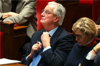 Der bisherige französische Premierminister Michel Barnier richtet seine Krawatte während der Debatte vor dem Misstrauensvotum gegen seine Regierung in der Nationalversammlung
