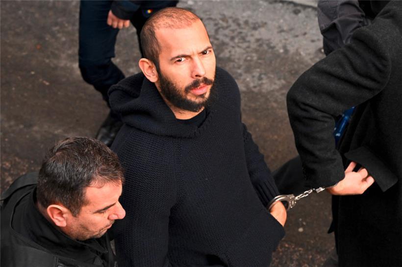 Der britisch-amerikanische Influencer Andrew Tate erscheint in Handschellen und in Polizeibegleitung in einem Gerichtsgebäude in Bukarest
