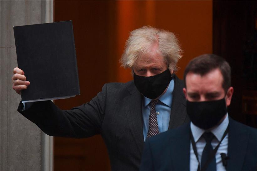 Der britische Premierminister Boris Johnson winkt, als er die Downing Street 10 im Zentrum Londons verlässt, um vor dem Parlament eine Erklärung über den Lockdown-Fahrplan abzugeben
