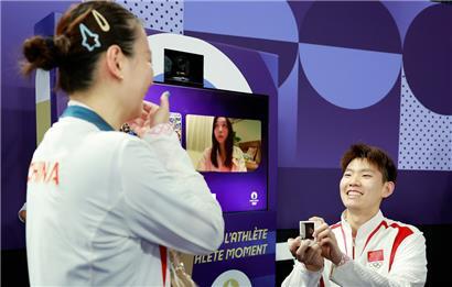 Der chinesische Badmintonspieler Liu Yuchen (r) macht der Goldmedaillengewinnerin Huang Ya Qiong in der Stadt der Liebe einen Heiratsantrag
