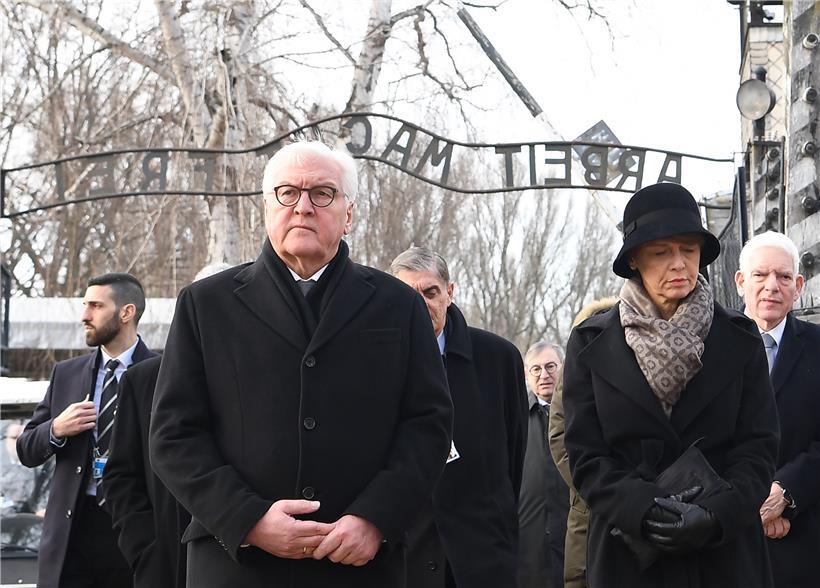 Der deutsche Bundespräsident Frank-Walter Steinmeier und seine Frau Elke Büdenbender durchqueren das Tor mit dem Schriftzug „Arbeit macht frei“ während der Gedenkfeier zum 75. Jahrestag der Befreiung des ehemaligen deutschen Konzentrationslagers Auschwitz
