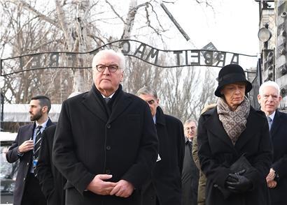 Der deutsche Bundespräsident Frank-Walter Steinmeier und seine Frau Elke Büdenbender durchqueren das Tor mit dem Schriftzug „Arbeit macht frei“ während der Gedenkfeier zum 75. Jahrestag der Befreiung des ehemaligen deutschen Konzentrationslagers Auschwitz
