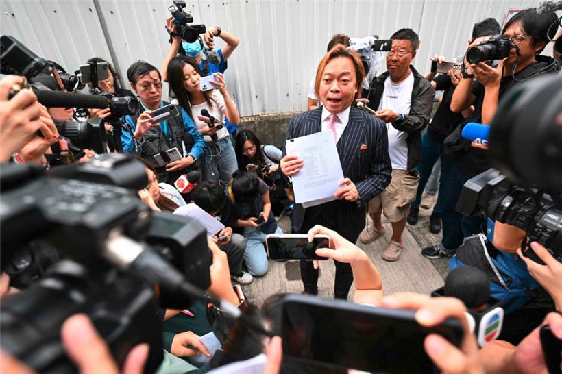Der ehemalige Bezirksrat Lawrence Lau spricht zu den Medien, nachdem er vor dem Magistratsgericht von West Kowloon in Hongkong für nicht schuldig befunden wurde
