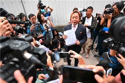 Der ehemalige Bezirksrat Lawrence Lau spricht zu den Medien, nachdem er vor dem Magistratsgericht von West Kowloon in Hongkong für nicht schuldig befunden wurde
