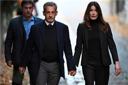 Der ehemalige französische Präsident Nicolas Sarkozy (Mitte) verlässt zusammen mit seiner Frau Carla Bruni-Sarkozy seine Residenz, um sich im Pariser Gefängnis La Santé zu melden
