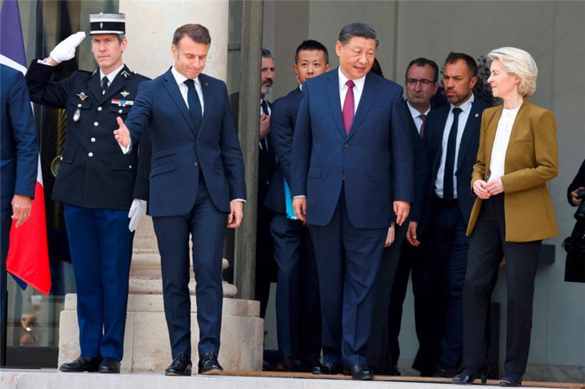 Der französische Staatspräsident Emmanuel Macron (l.) geht voran, während sein chinesischer Gast Xi Jinping mit der EU-Kommissionspräsidentin Ursula von der Leyen spricht
