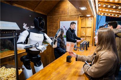 Der humanoide Roboter „Optimus“ von Tesla verteilt bei seiner Vorstellung in der Mall of Berlin Popcorn
