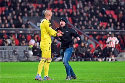 Der in Schwarz gekleidete Fan schlug den Sevilla-Torhüter Marko Dmitrovic mit der linken Faust ins Gesicht

