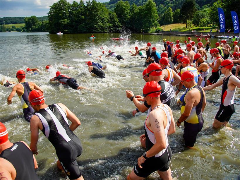 Teilnehmer beim internationalen Trilux Triathlon 1984 beim Schwimmen, Laufen und Radfahren in einem Wettkampf