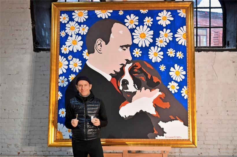 Der russische Maler Alexey Sergienko vor seinem Werk „Putin mit einem Hundewelpen“, das er dem Kremlchef zum seinem 70. Geburtstag gemalt hat
