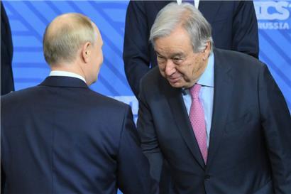 Der russische Präsident Wladimir Putin (l.) und der Generalsekretär der Vereinten Nationen, Antonio Guterres, schütteln sich während einer Zeremonie zum Familienfoto im Rahmen des Brics-Gipfels die Hände
