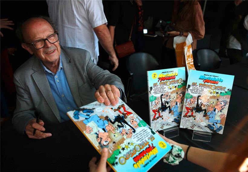 Der spanische Comic-Zeichner Francisco Ibáñez signiert einige Comic-Bücher 
