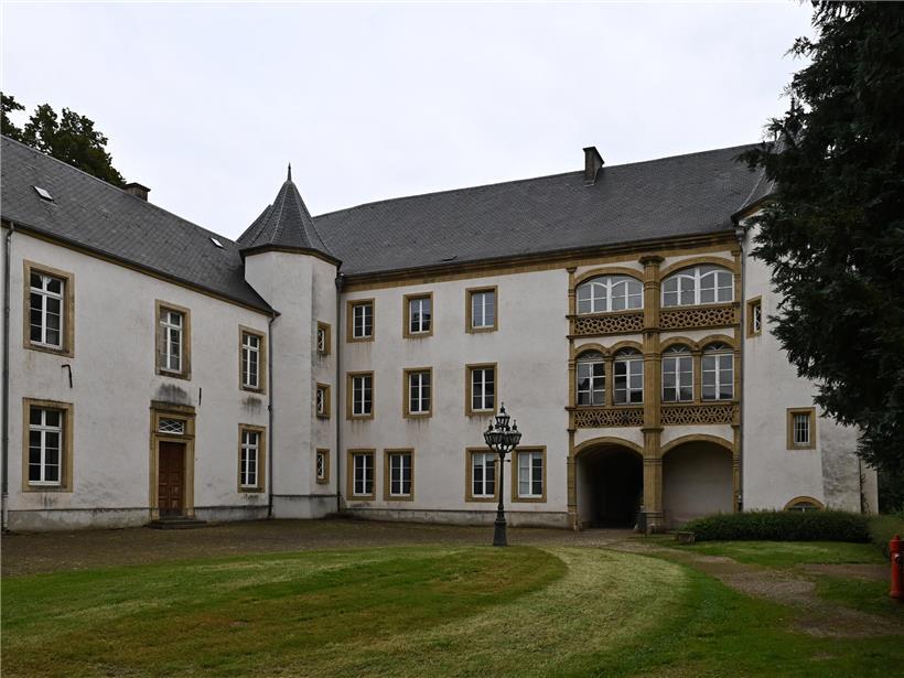 Innenhof von Schloss Sanem mit Blick auf den Park, historische Architektur und grüne Gartenanlage