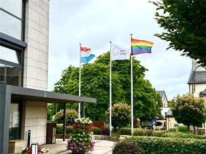 Regenbogenflagge für Vielfalt und Toleranz weht vor dem Rathaus in Contern an sonnigem Tag