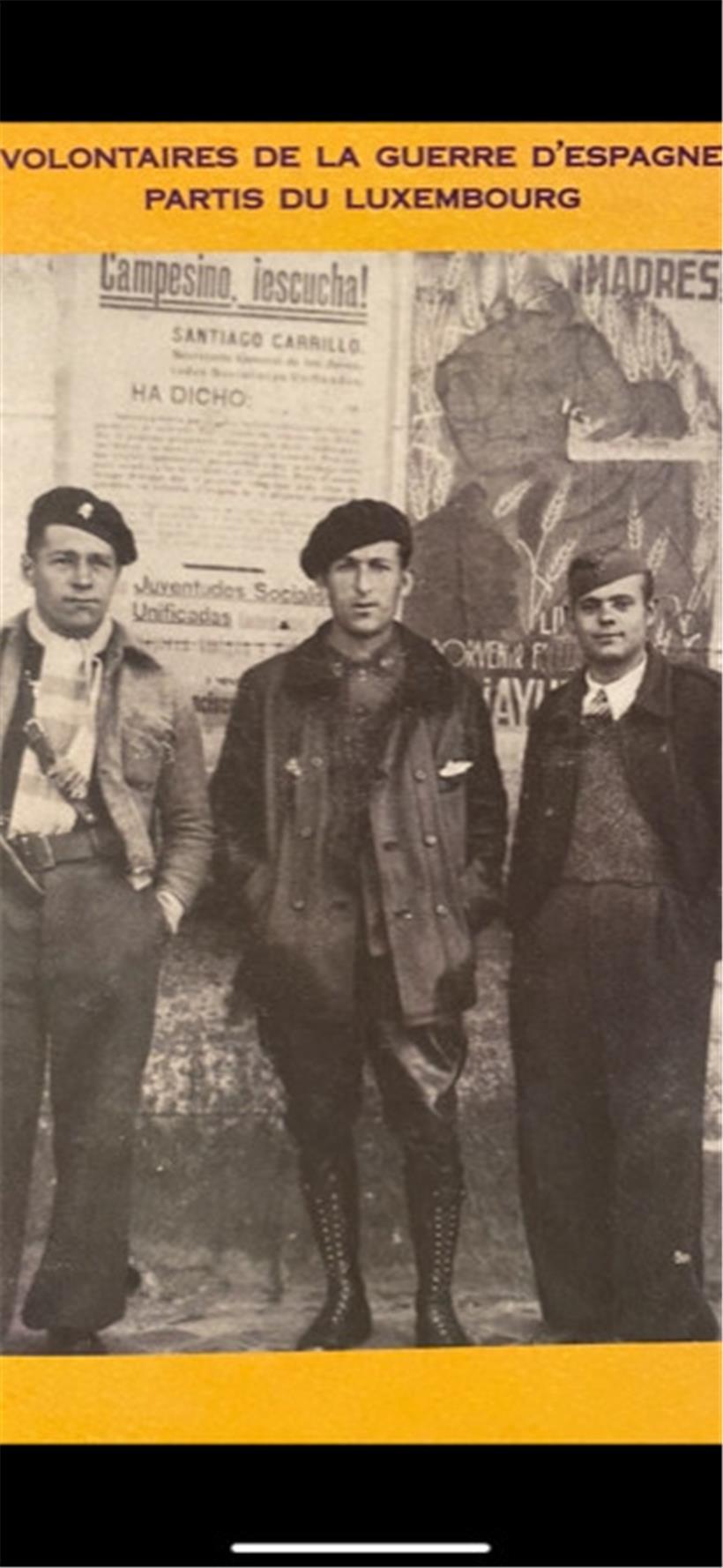 Des combattants des Brigades internationales: à droite Willy Bremer de Rumelange avec en arrière-plan sur le mur une affiche des Jeunesses socialistes unifiées d’Espagne
