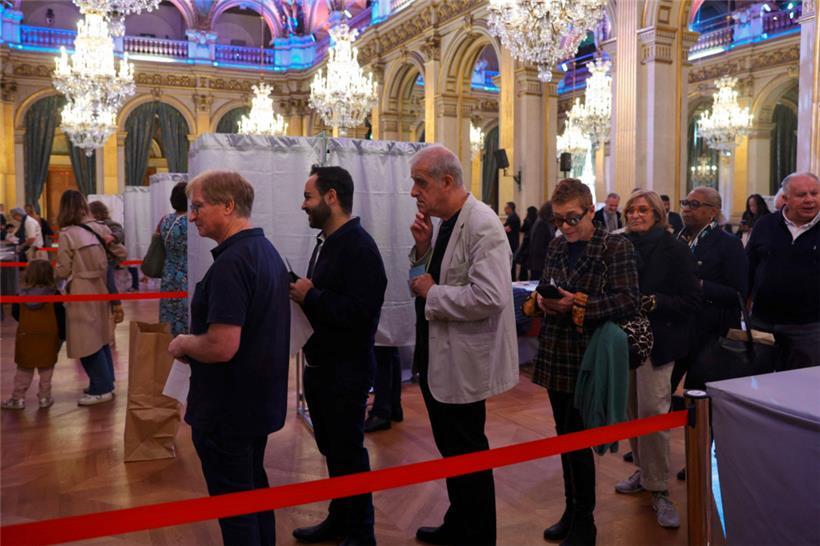 Des électeurs font la queue dans un bureau de vote à la mairie de Paris 
