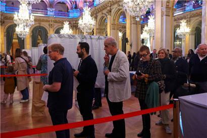 Des électeurs font la queue dans un bureau de vote à la mairie de Paris 
