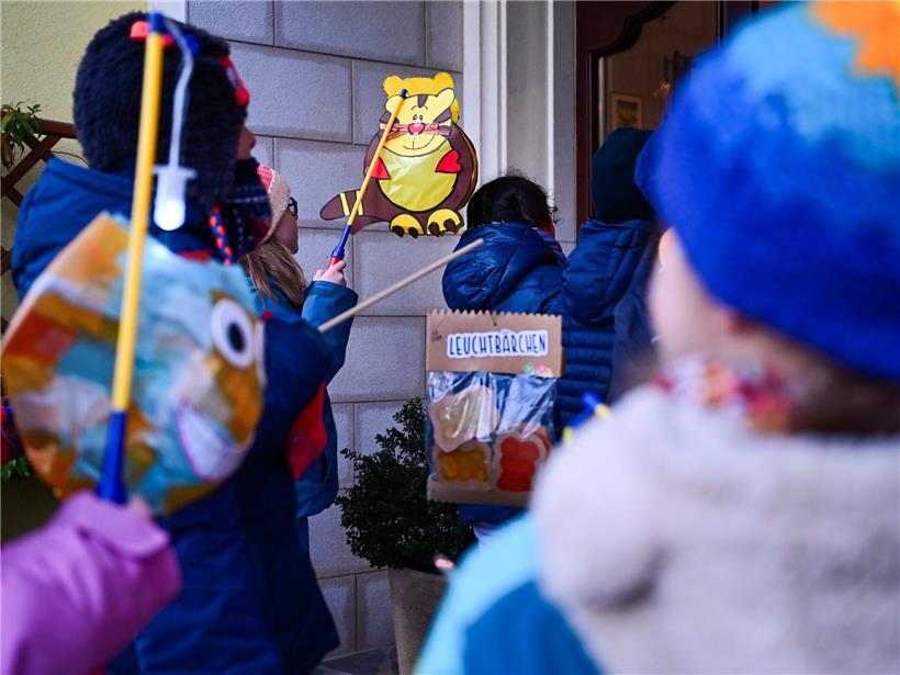 Kanner déi dëse Méinde mat faarwege Lampione am Nuechtspazéiergang liichten