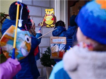 Kanner déi dëse Méinde mat faarwege Lampione am Nuechtspazéiergang liichten