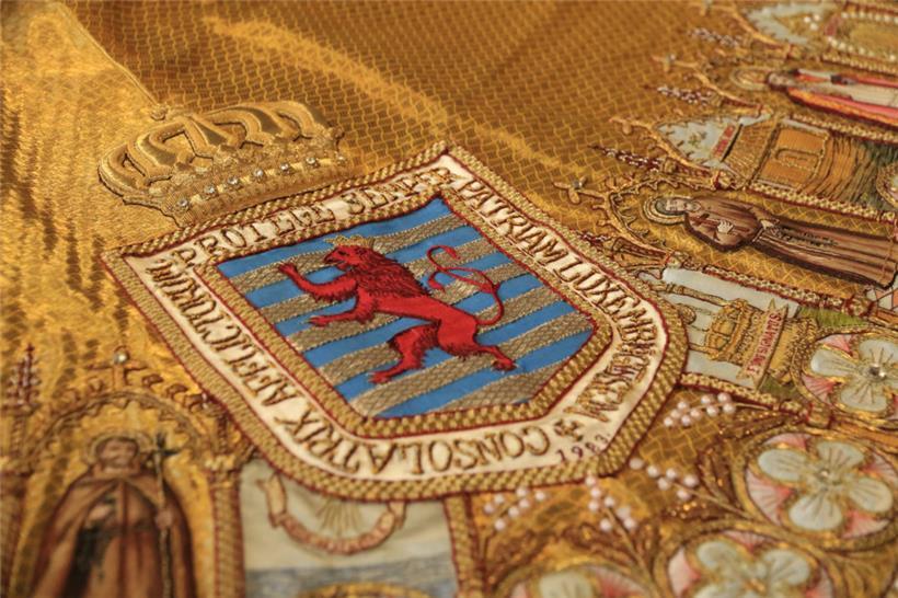 Detail aus dem Buch: Stoff mit bekröntem Wappen von Luxemburg und der Jahreszah...