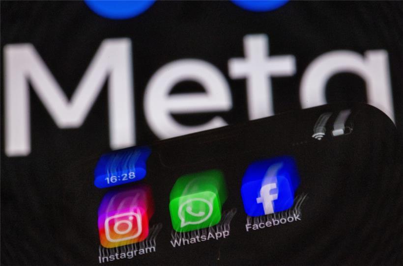 Die Apps Instagram, Facebook und WhatsApp auf einem Display eines Smartphones vor dem Logo des Internetkonzerns Meta
