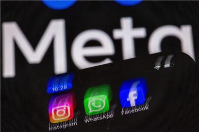 Die Apps Instagram, Facebook und WhatsApp auf einem Display eines Smartphones vor dem Logo des Internetkonzerns Meta
