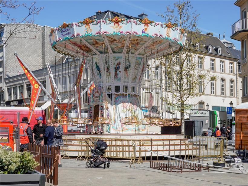 Aufbauarbeiten mit Bauarbeitern und Maschinen auf einer Baustelle bei strahlendem Sonnenschein