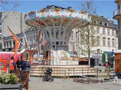 Aufbauarbeiten mit Bauarbeitern und Maschinen auf einer Baustelle bei strahlendem Sonnenschein