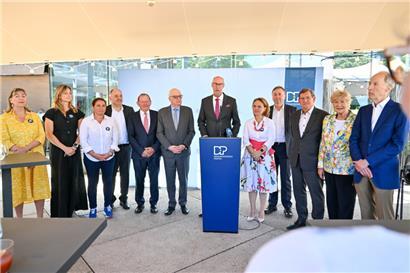 Die DP-Fraktion vor der „Brasserie Schuman“, Fraktionschef Gilles Baum am Rednerpult
