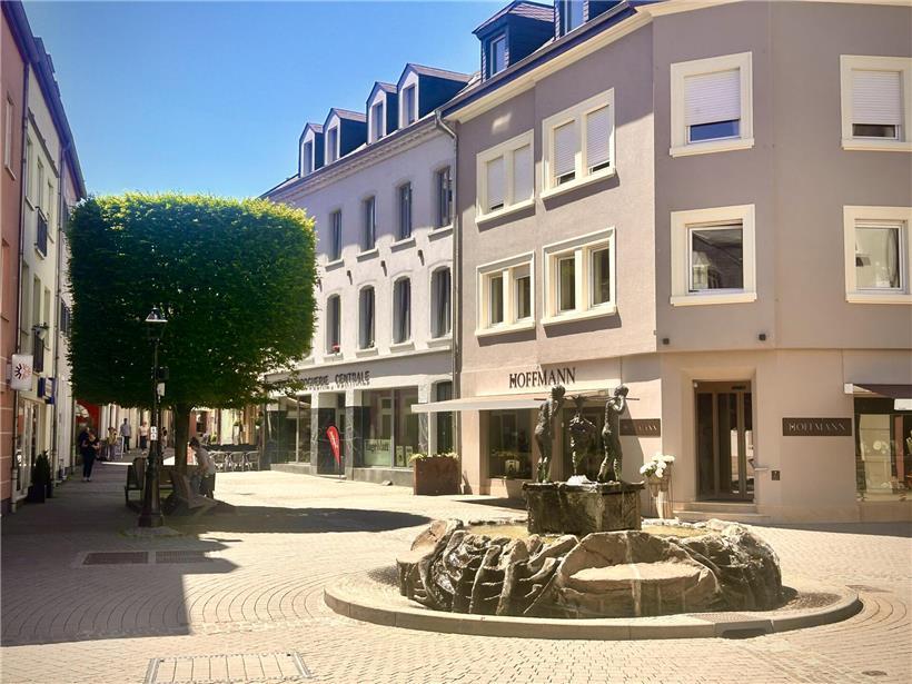 Fußgängerzone in Grevenmacher mit Cafés, Geschäften und Menschen bei sonnigem Wetter