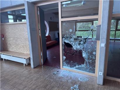 Glasscheibe mit Feuerlöscher zerbrochen, Sicherheitsglasbruch durch Notfallmaßnahme sichtbar