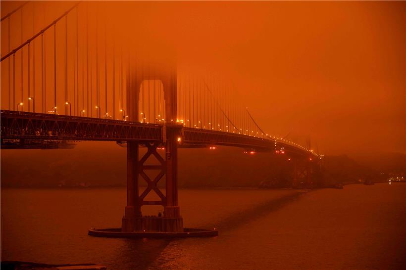 Die Golden Gate Bridge in San Francisco ist in orangen Rauch gehüllt
