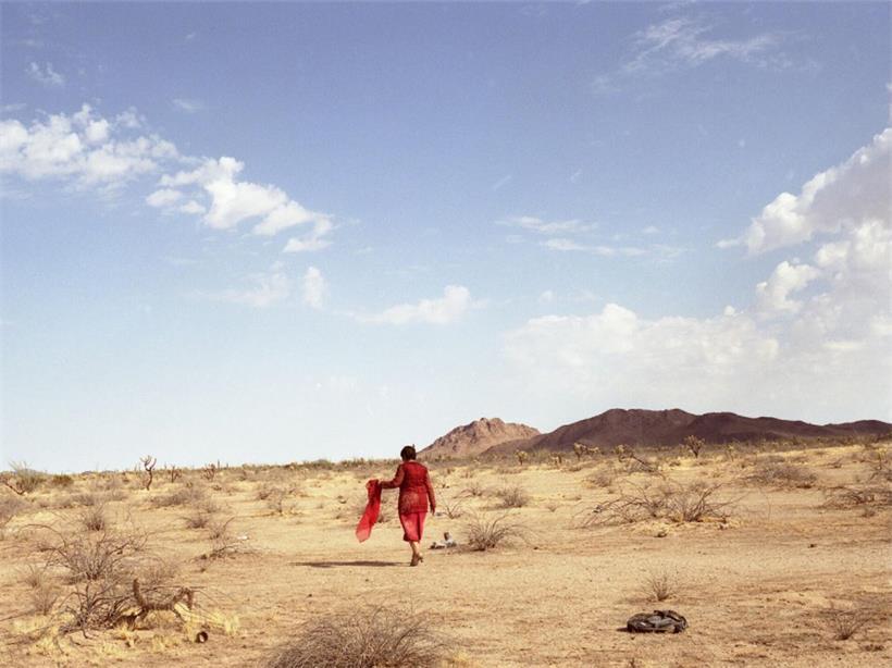 Haushälterin Amelia (Adriana Barraza) steht in der Wüste bei sonnigem Himmel, Szenenbild aus Film und Drama