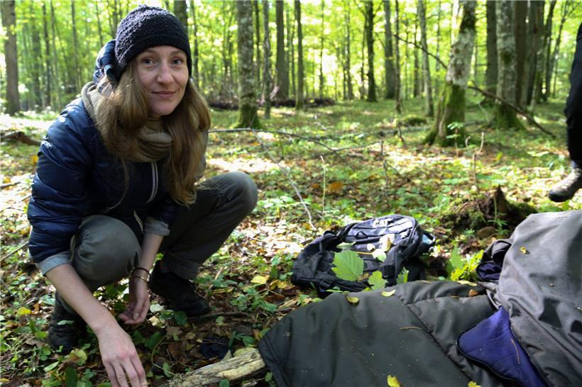 Die Helferin Maria Zlonkiewicz kniet in einem Wald bei Hajnowka nahe der polnisch-belarussischen Grenze neben Gegenständen, die wahrscheinlich von Flüchtlingen aus dem Nahen Osten zurückgelassen wurden
