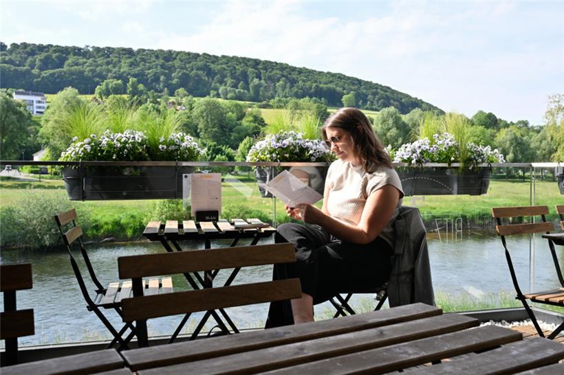 Die Ladenterrasse am Ufer der Sauer im Hintergrund