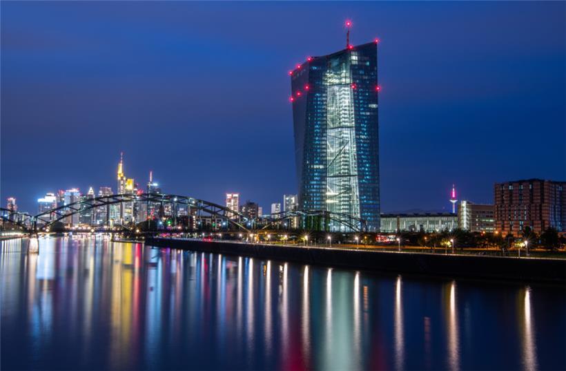 Die Lichter der Frankfurter Bankenskyline und der Europäischen Zentralbank (EZB) spiegeln sich im Main. Wann die Zinsen im Euroraum erstmals wieder steigen sollen, bleibt nach wie vor offen.
