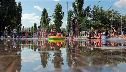 Die Menschen kühlen sich in Madrid unter Wasserfontänen ab
