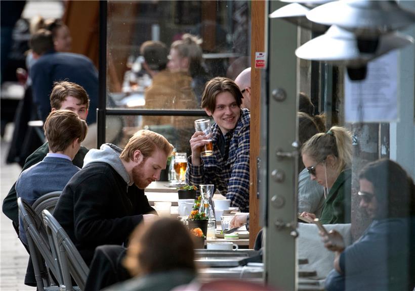 Die Menschen sitzen im Stadtzentrum auf der Terrasse eines Restaurants in Stockholm. Während in großen Teilen Europas die Menschen wegen der Coronavirus-Pandemie zu Hause bleiben müssen, dürfen sich die Schweden weiter zum Bier treffen, Sport treiben und zum Friseur gehen. 
