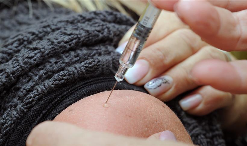 Die Menschen warten weltweit auf eine Corona-Impfung. Das Bild zeigt eine Person, die gerade eine Grippeimpfung erhält.
