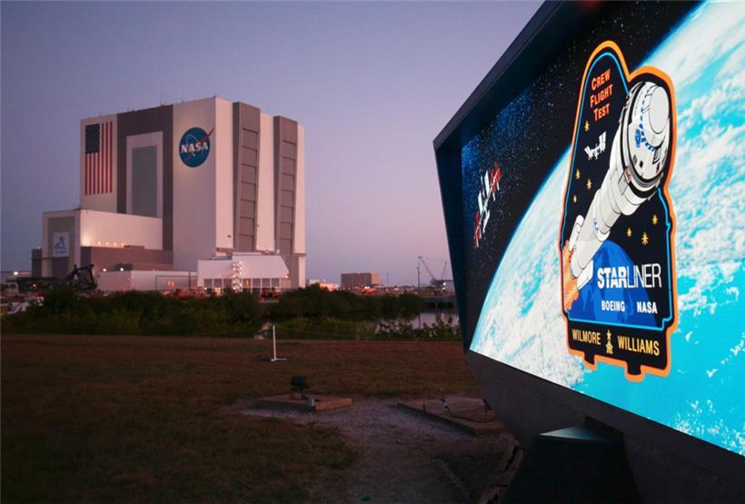Die Missions-Countdown-Uhr mit dem Vehicle Assembly Building der NASA vor Sonnenaufgang im Kennedy Space Center in Cape Canaveral
