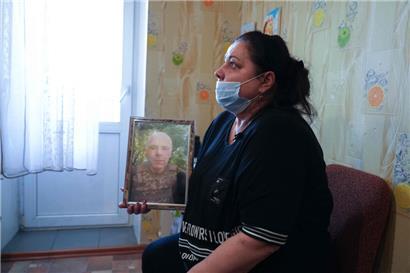 Die Mutter von Bogdan Lewtschikow, Iryna, mit einem Bild ihres im Kampf gefallenen Ehemanns Stanislaw. Iryna leidet an Krebs in fortgeschrittenem Stadium.
