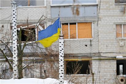 Die Nationalflagge der Ukraine steht vor einem zerstörten Gebäude im ukrainischen Borodjanka
