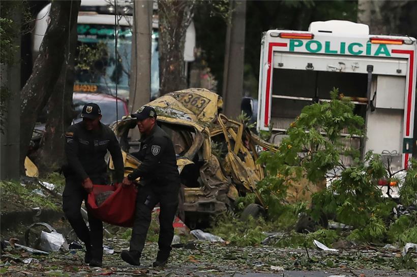 Die Polizei beseitigt die Trümmer einer Bombenexplosion vor einem Luftwaffenstützpunkt in Cali
