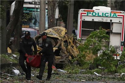 Die Polizei beseitigt die Trümmer einer Bombenexplosion vor einem Luftwaffenstützpunkt in Cali

