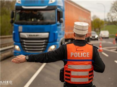Polizeikontrolle von Lkw-Fahrern auf der Straße zur Überprüfung von Transport- und Sicherheitsvorschriften
