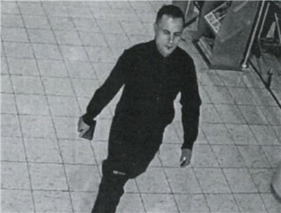 Polizeiliches Fahndungsbild einer gesuchten Person, Gesicht frontal, helle Haut, kurze dunkle Haare, neutrale Mimik