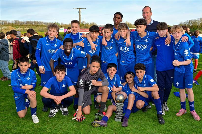 Siegermannschaft posiert strahlend mit Trainer Jeff Strasser nach dem Turniersieg