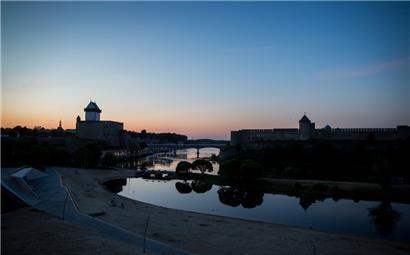 Die Sonne geht hinter der Hermannsfeste (l) in der estnischen Stadt Narva und der russischen Burg Iwangorod auf der gegenüberliegenden Seite unter. Zwischen Estland und Russland fließt hier die Narva entlang
