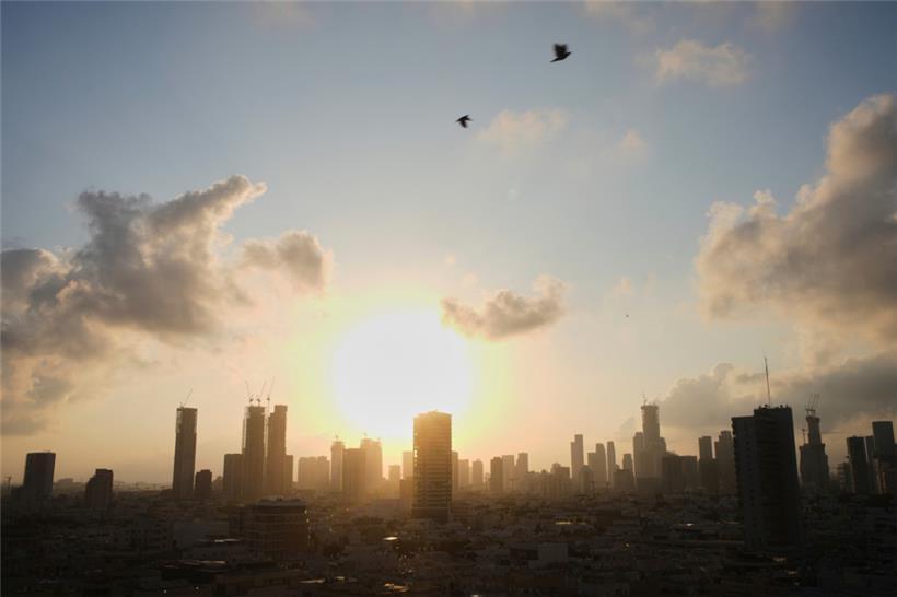 Die Sonne geht hinter der Stadtsilhouette in Tel Aviv auf
