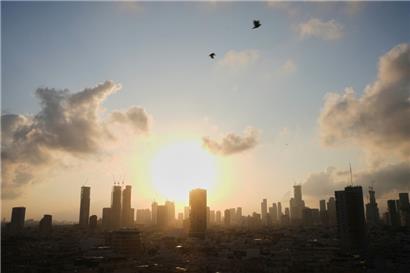 Die Sonne geht hinter der Stadtsilhouette in Tel Aviv auf
